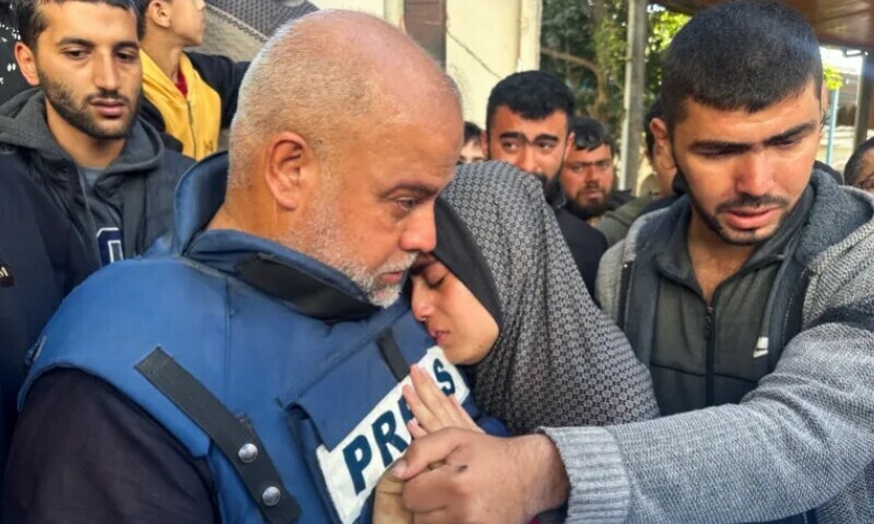 Wael Al-Dahdouh hugs his daughter as they attend the funeral of his son Hamza