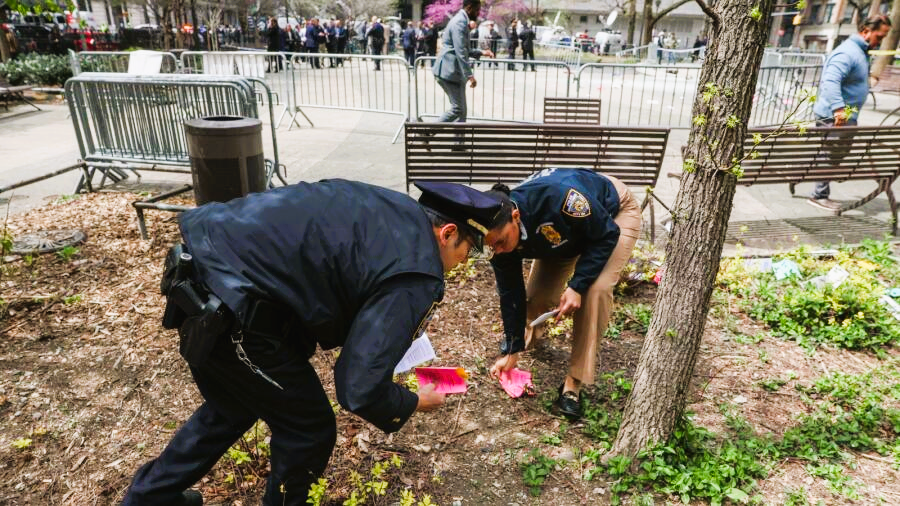 Police officers collect pamphlets dropped by a person who was covered in flames outside the courthouse where Donald Trump's criminal hush money trial is underway, in New York. — Reuters